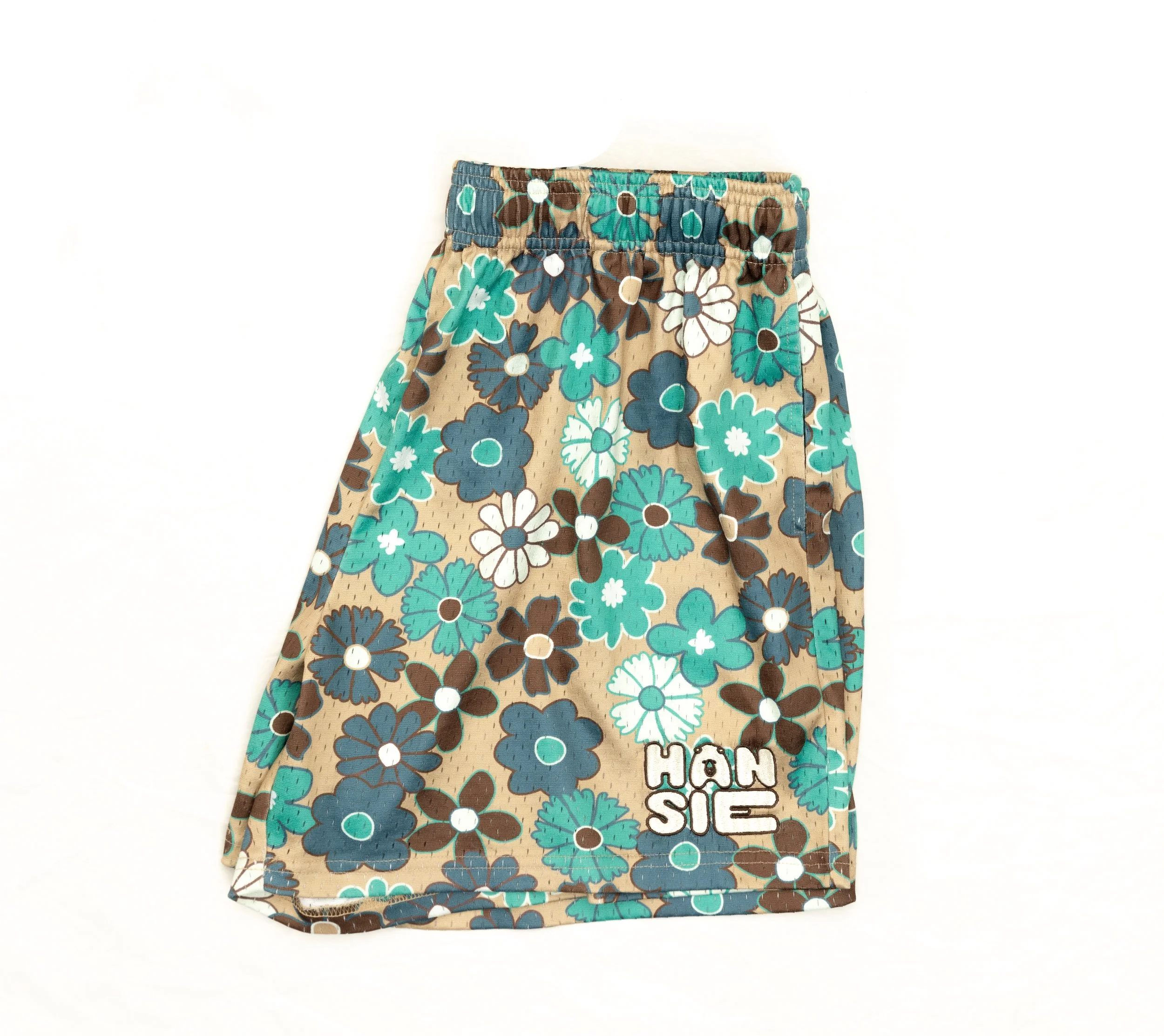 A beige skirt with a floral pattern in teal, white, and brown, featuring the words 'HANSIE' at the bottom.
