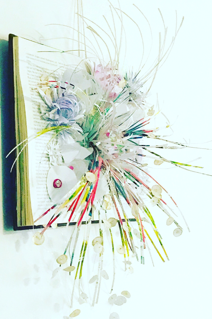 Aquatic paper sculpture featuring coral forms and oceanic flora featured on an upcycled book. Created by artist Leesa Maree.