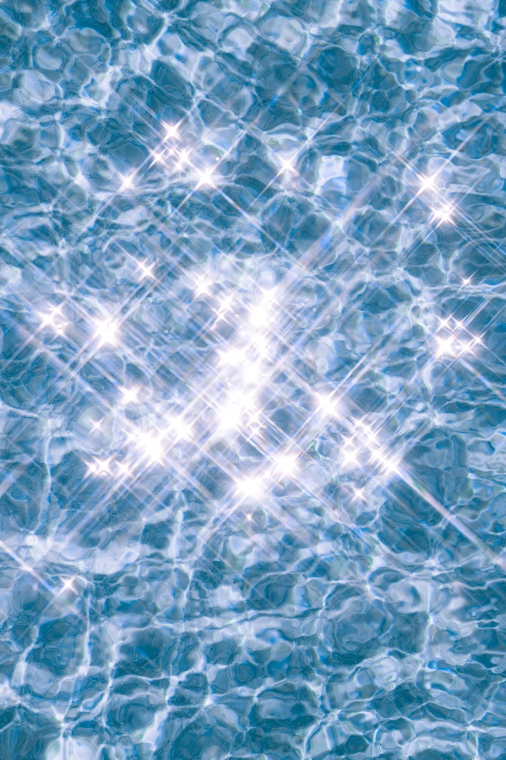 Sparkling sunlight on the surface of a swimming pool, creating a shimmering, reflective pattern.