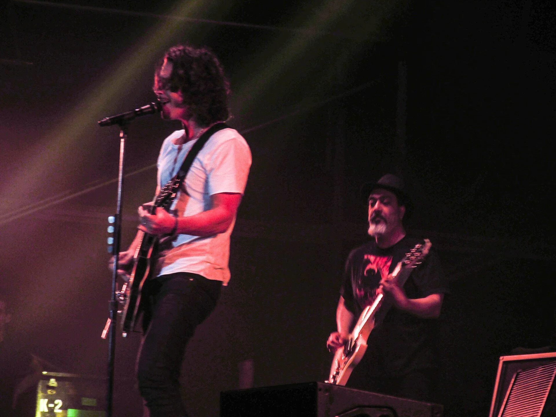 Chris Cornell on stage in white T-shirt.