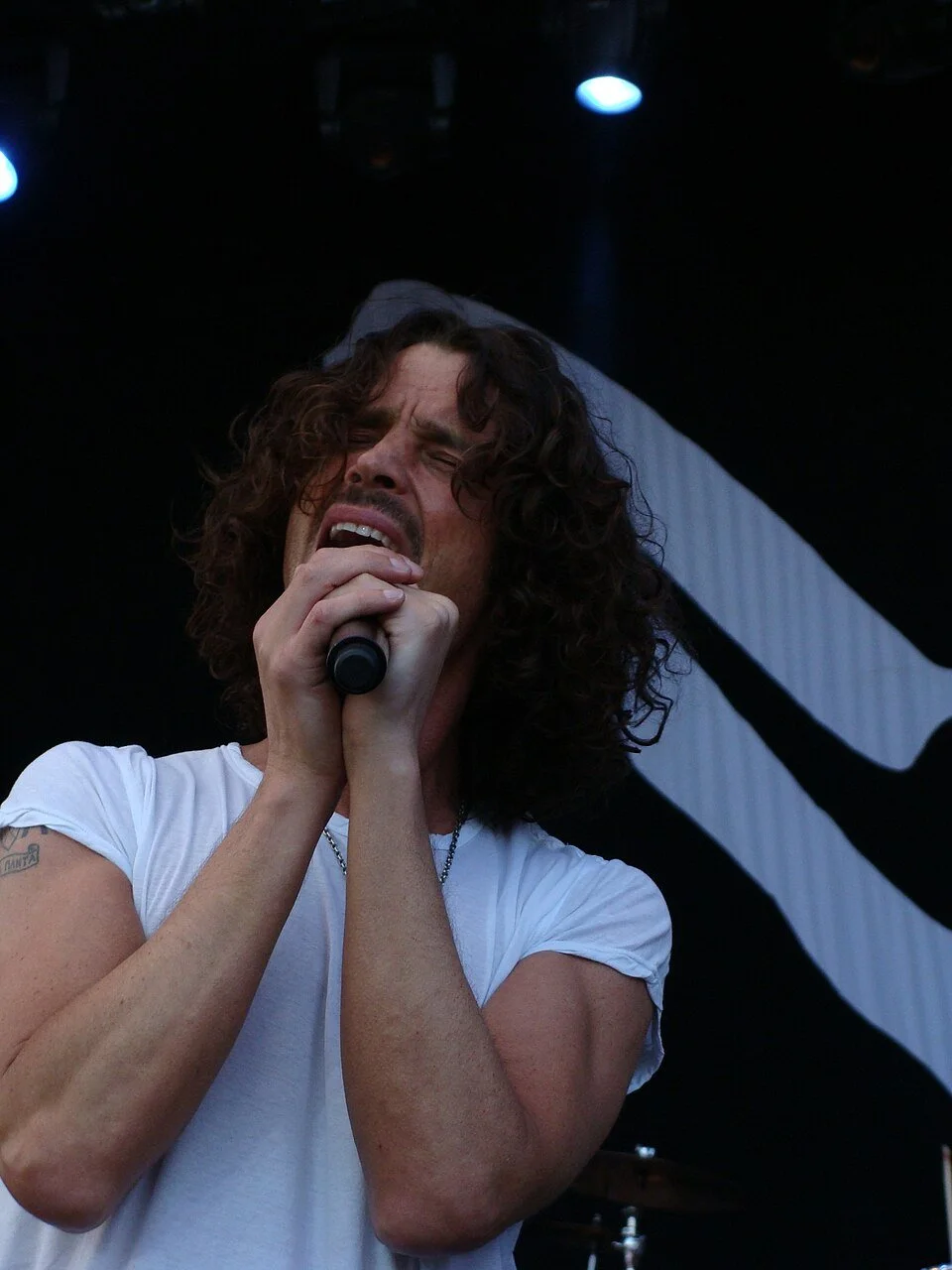 Close up of Chris Cornell signing into microphone.