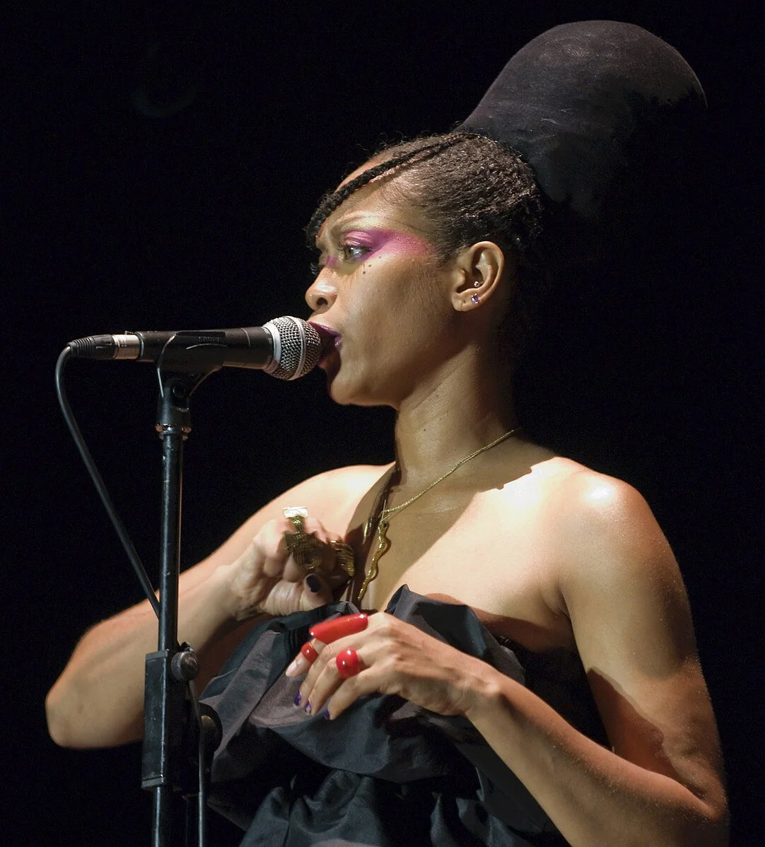 Erica Badu at the microphone singing.