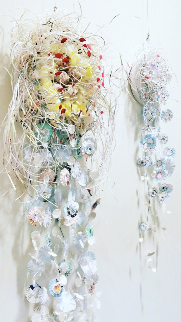 Two paper sculpture works with round intricate shapes and wild thin organic paper representing a jellyfish. Featured at Raymond Terrace Library Gallery.