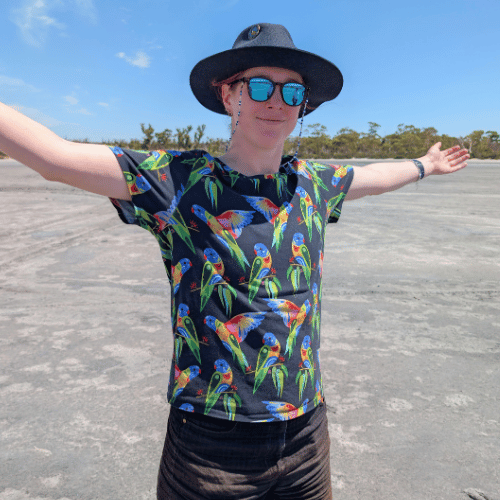 Emi is wearing a bird top, reflective sunglasses and a hat