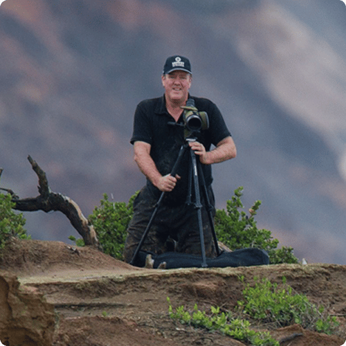 Victor is standing and setting up a camera with a tripod