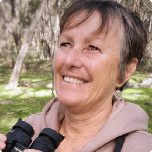 Merrilyn is holding binoculars and looking up with joy