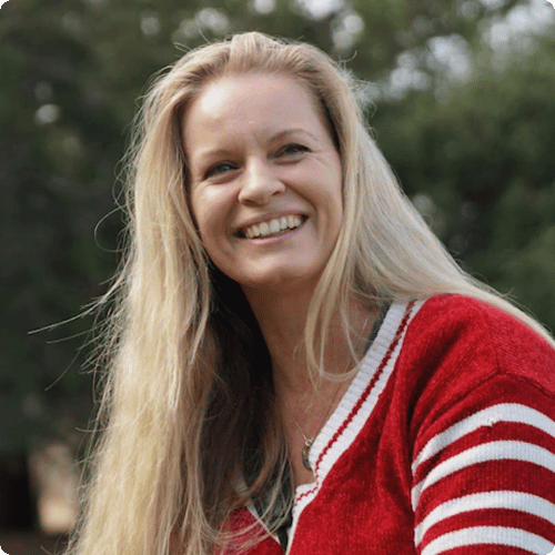 Mandy has long blonde hair and is wearing a red and white stripey jumper