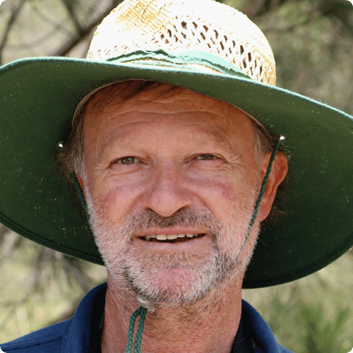 Close up imagine of Peters face, he wears a green wide brimmed hat and has a grey short beard