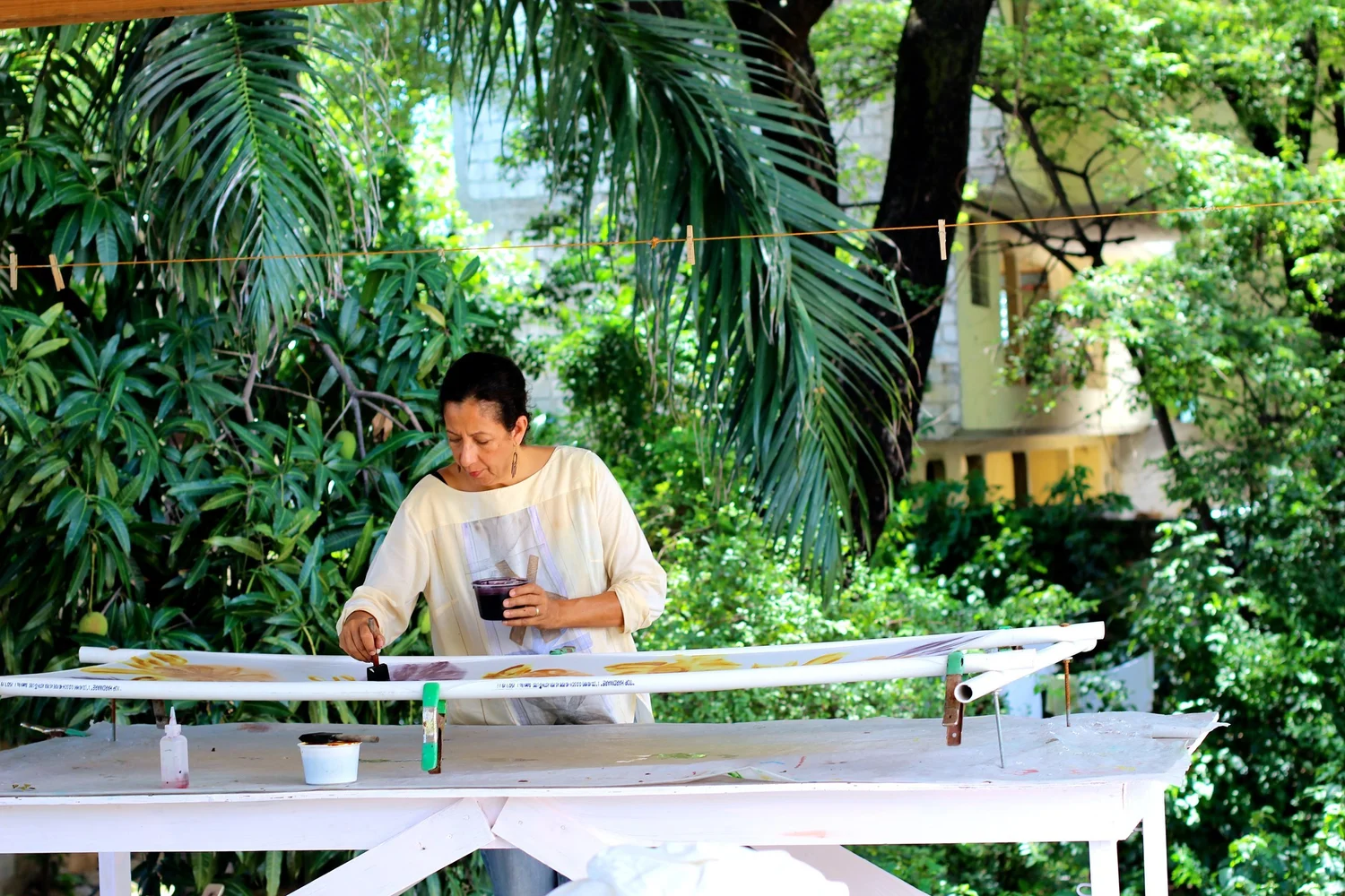 Sandra Russo painting textile in the Port-au-Prince atelier garden