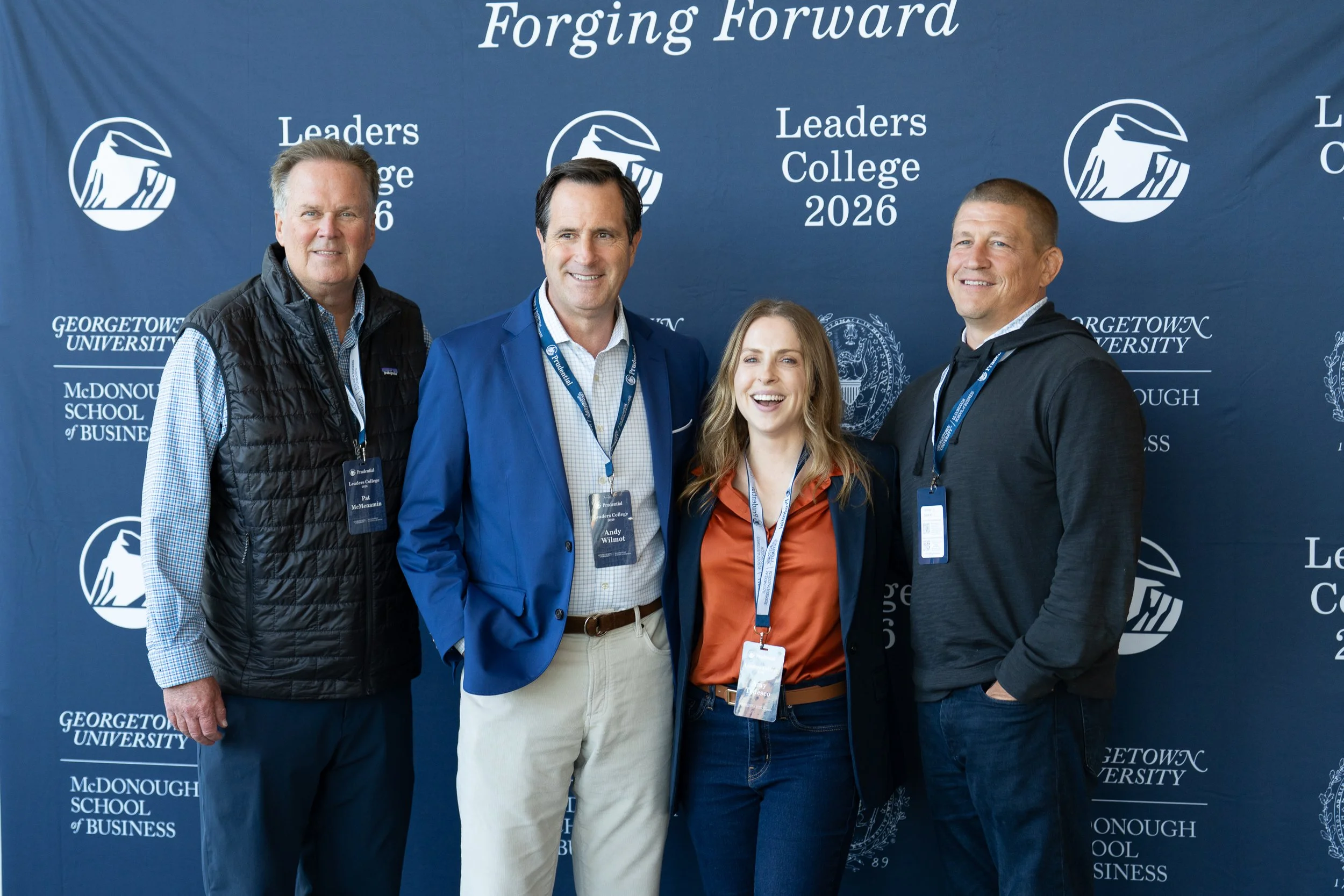 Four individuals standing in front of a blue Georgetown University backdrop that reads 'Forging Forward Leaders College 2026,' with university logos. They are smiling and wearing conference badges.