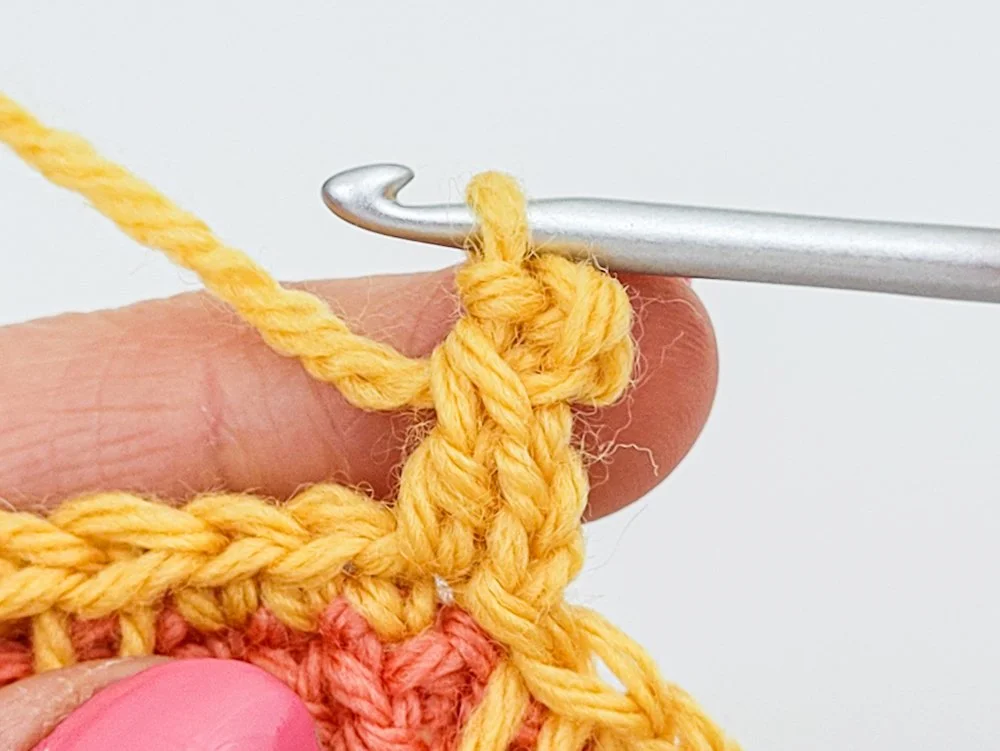 A completed picot worked in yellow yarn.