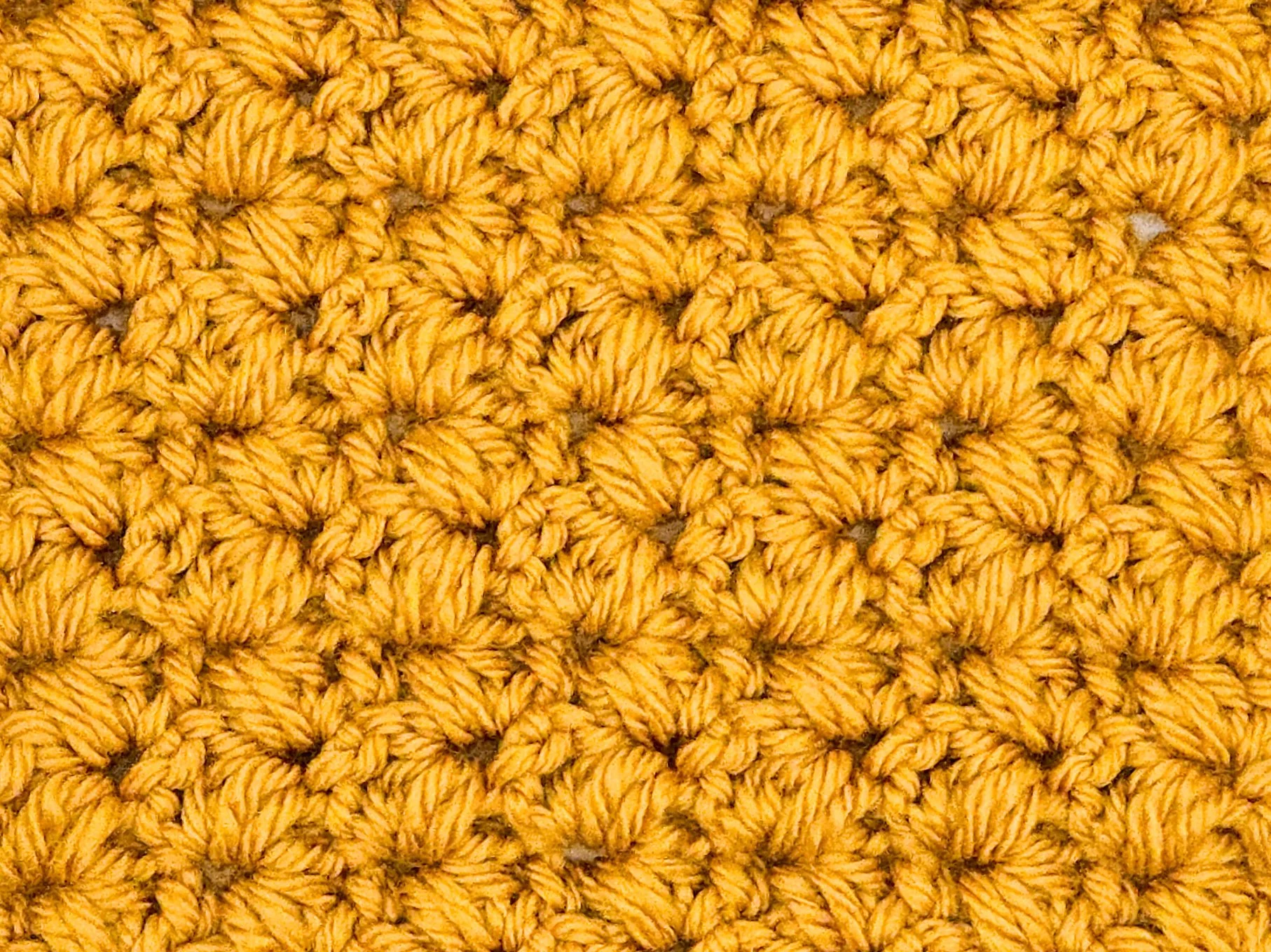 Close-up of the rocking puff V-stitch crochet stitch, which creates a highly textured fabric.