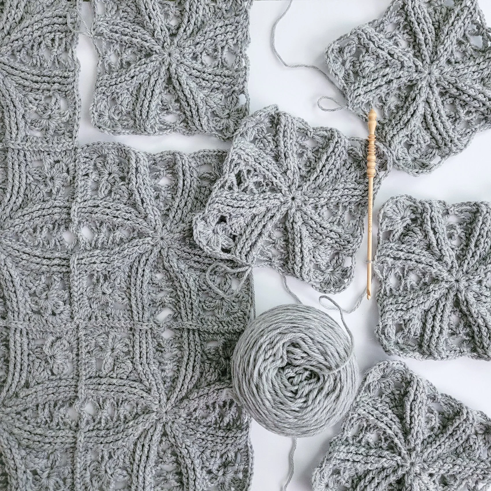 Double Wedding Ring Blanket stitched with gray yarn is laid flat on a white background to highlight the interlocking rings created by front post stitches.