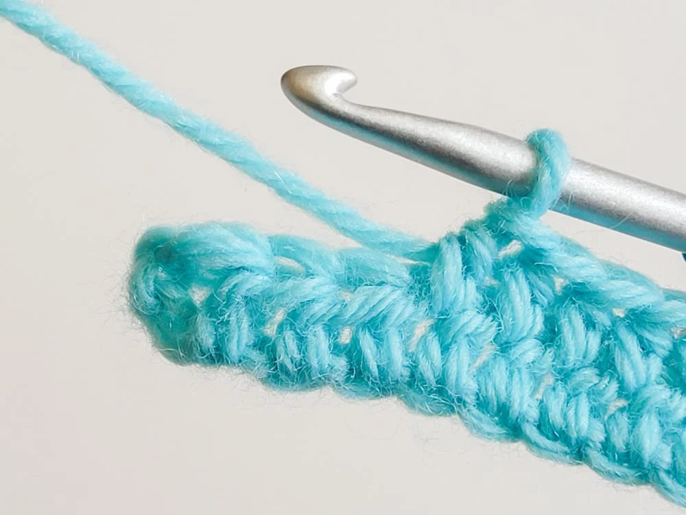 An hdc has been made in the space between each stitch across. Four stitches remain at the end of the row.