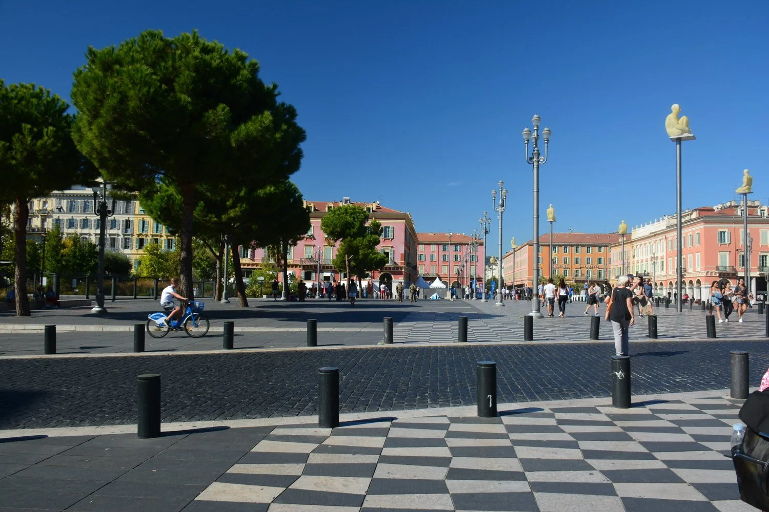  New plaza with funky stone walkway and men sitting on poles representing peace. &nbsp;This part of Nice was destroyed in WWII and this is what they built to replace that which was destroyed. 
