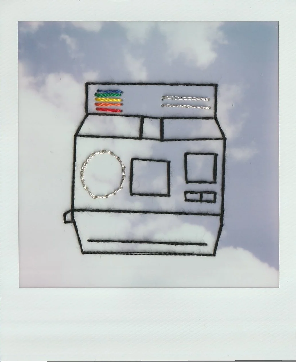 embroidered outline of a Polaroid 600 camera on a Polaroid with a cloudy sky background.