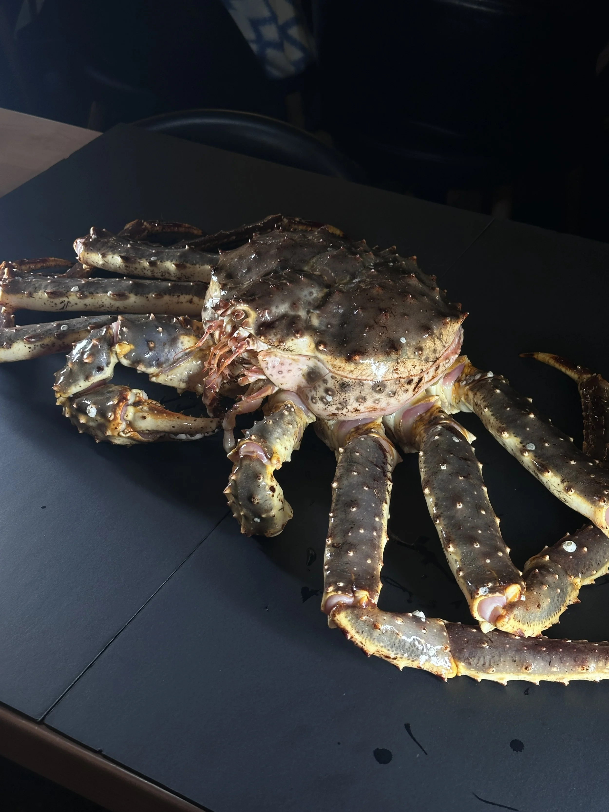 Raw whole crab placed on a black table.