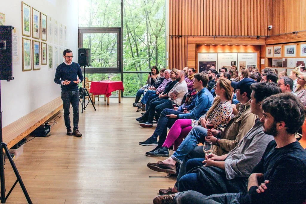 David, dressed in navy blue longsleeve shirt and black jeans, gives a talk to a packed room inside the modern, brightly lit setting of the Scottish Storytelling Centre.