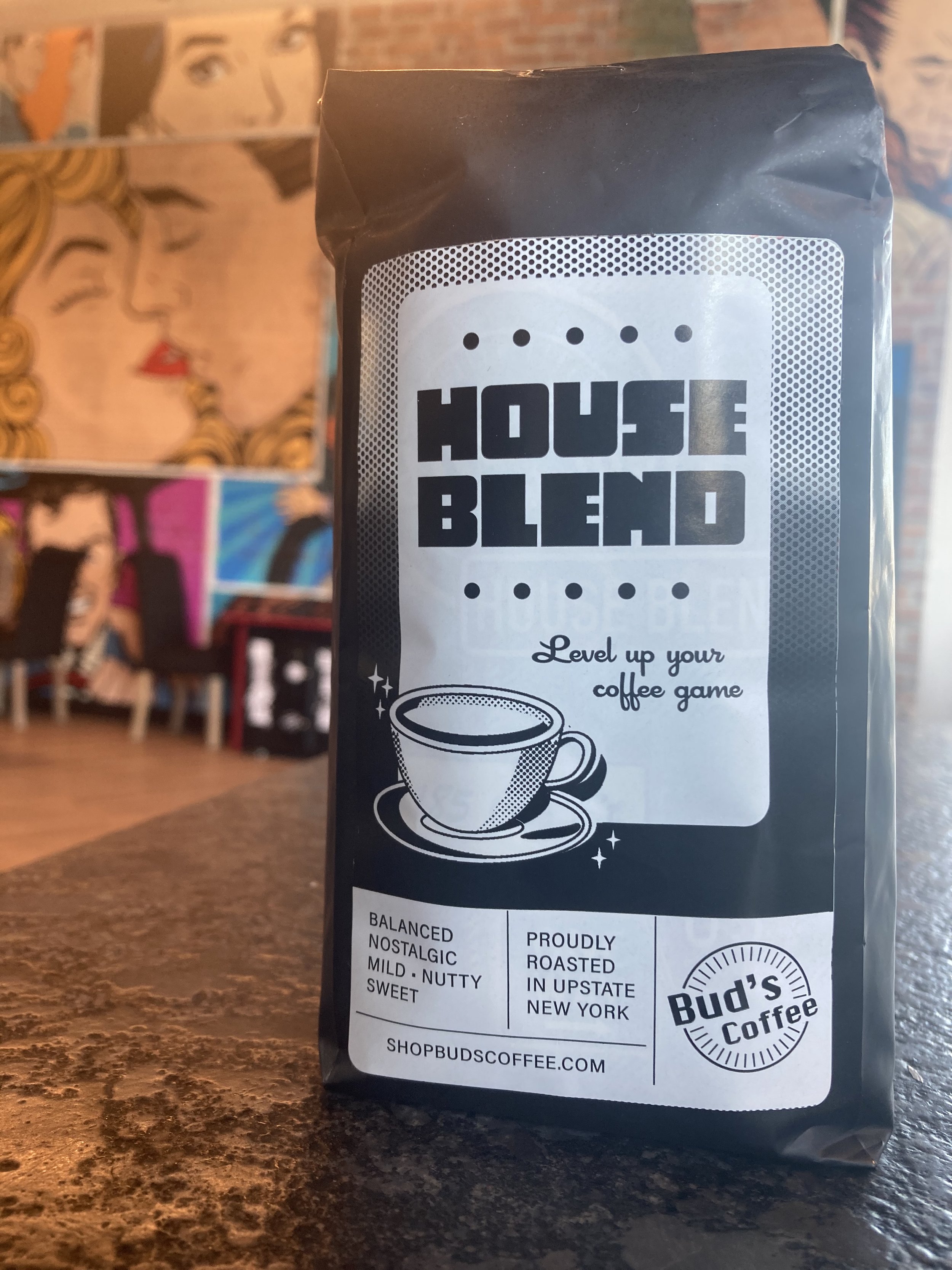 Bud's House Blend Coffee bag featured in front of our arcade tables and iconic pop art wallpaper in out Bud's on the Hudson coffeehouse located at 10 Starbuck Dr, Green Island, New York