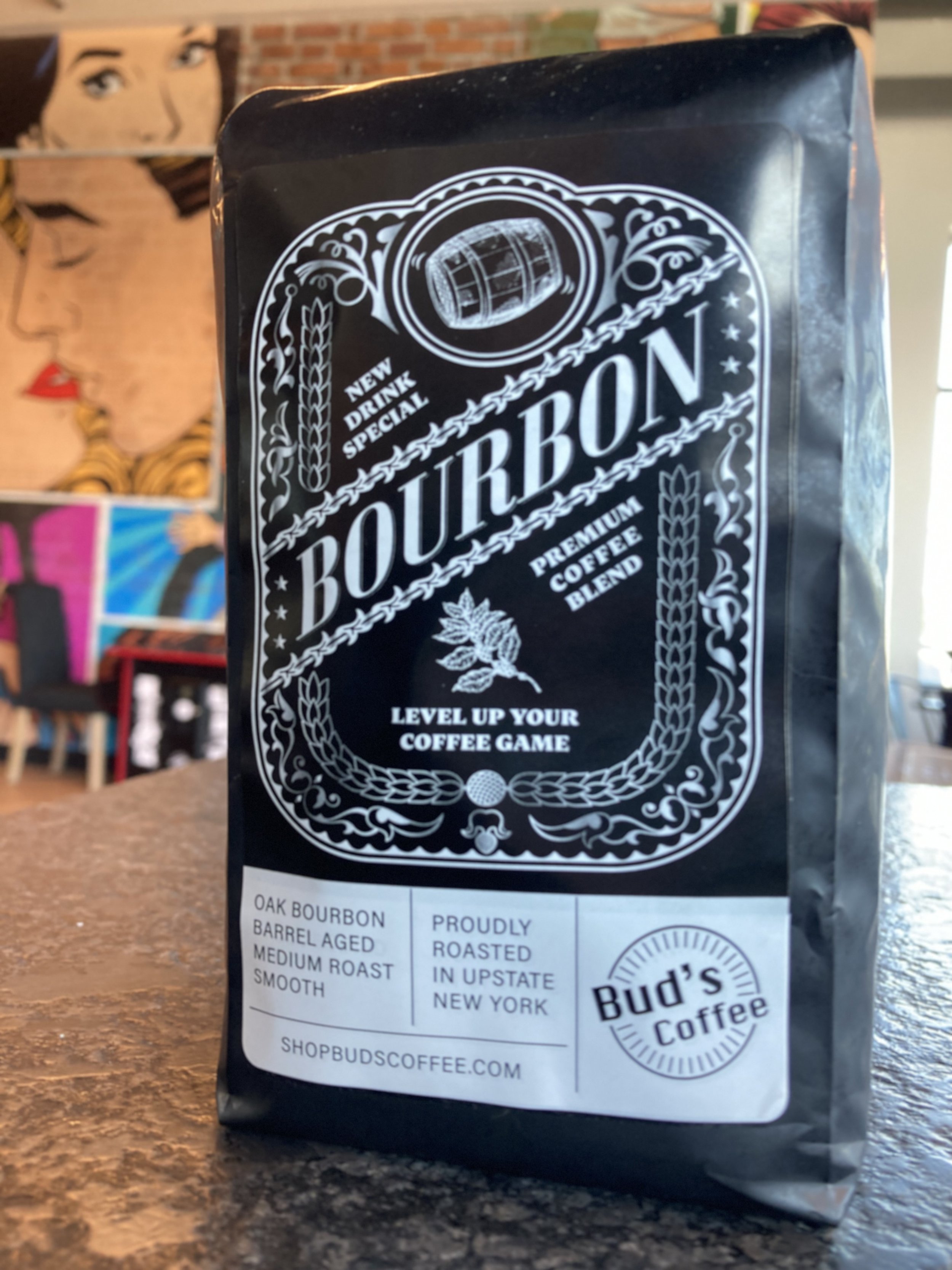 Bud's Bourbon Coffee bag featured in front of our arcade tables and iconic pop art wallpaper in out Bud's on the Hudson coffeehouse located at 10 Starbuck Dr, Green Island, New York.