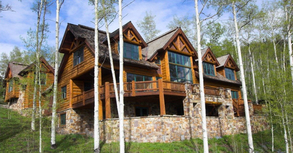 A beautiful, large log home features big windows, an expansive back porch, and a walkout basement.