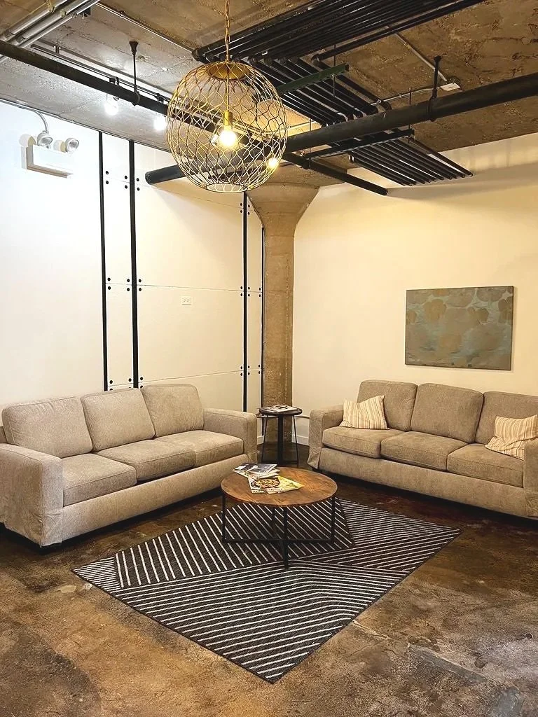 InnerBloom Therapy Practice modern office with comfortable neutral colored couches, patterned rugs, wall art, and warm, ambient environmental lighting in Chicago, IL