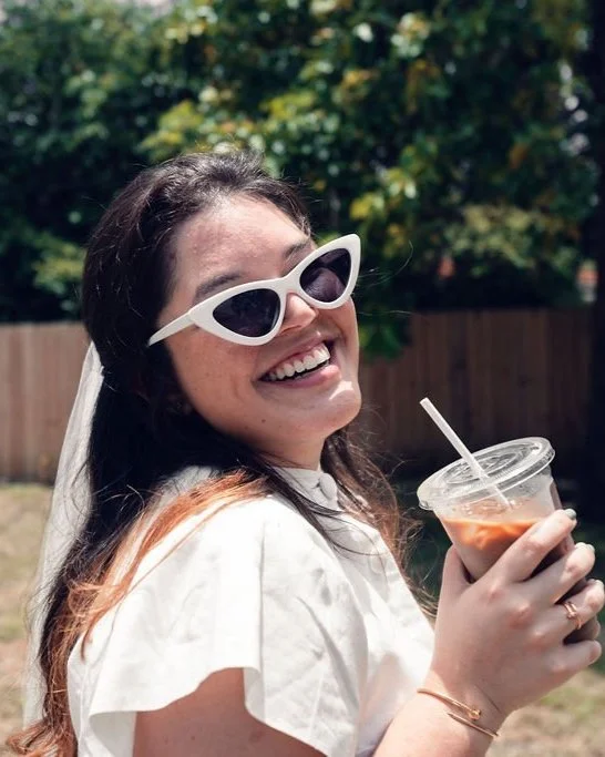 Bride drinking iced latte at outdoor wedding catered by Villette