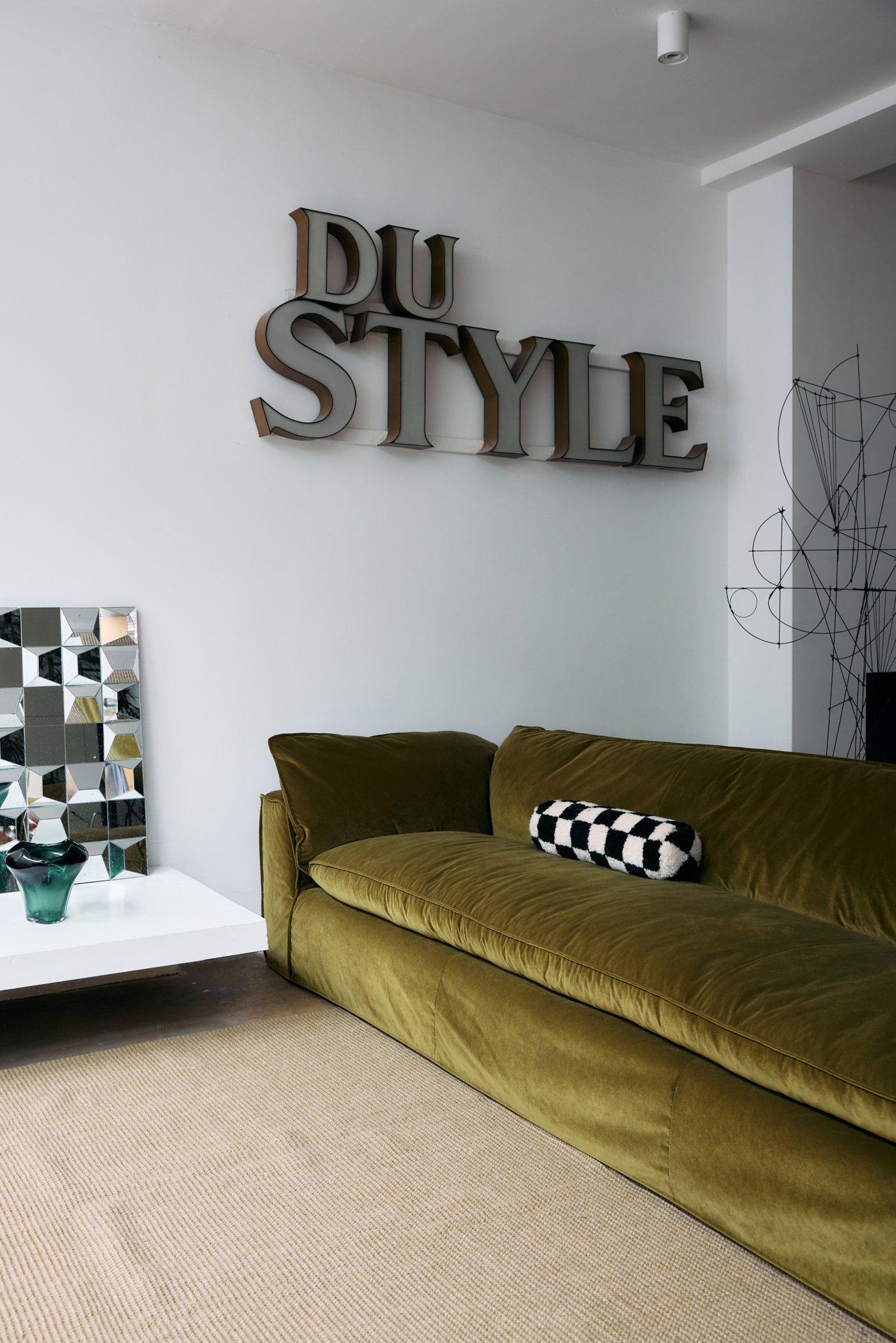 Jute tapijt in natuurlijke kleur ligt in de woonkamer voor een groene sofa - David & Dupont Koksijde.jpg