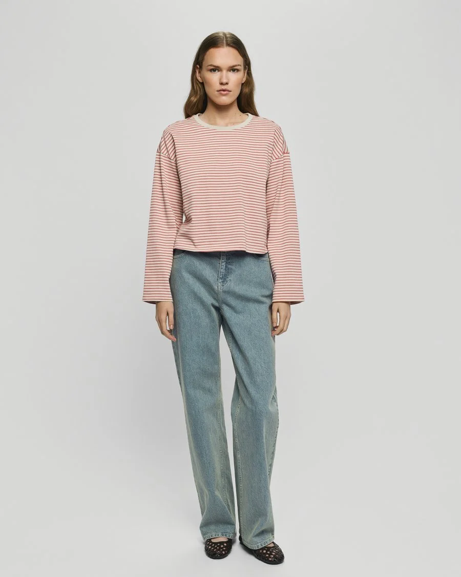 Vrouw draagt MSCHKrestiane met wit en roze gestreepte pullover van Moss Copenhagen.