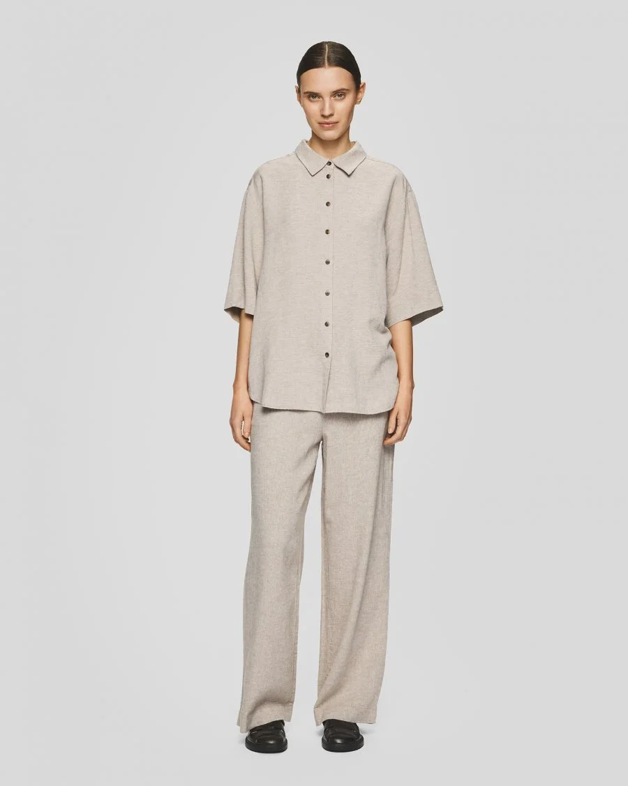 Vrouw met beige hemd en broek type MSCHPennie Ginia HW Pants van merk Moss Copenhagen.