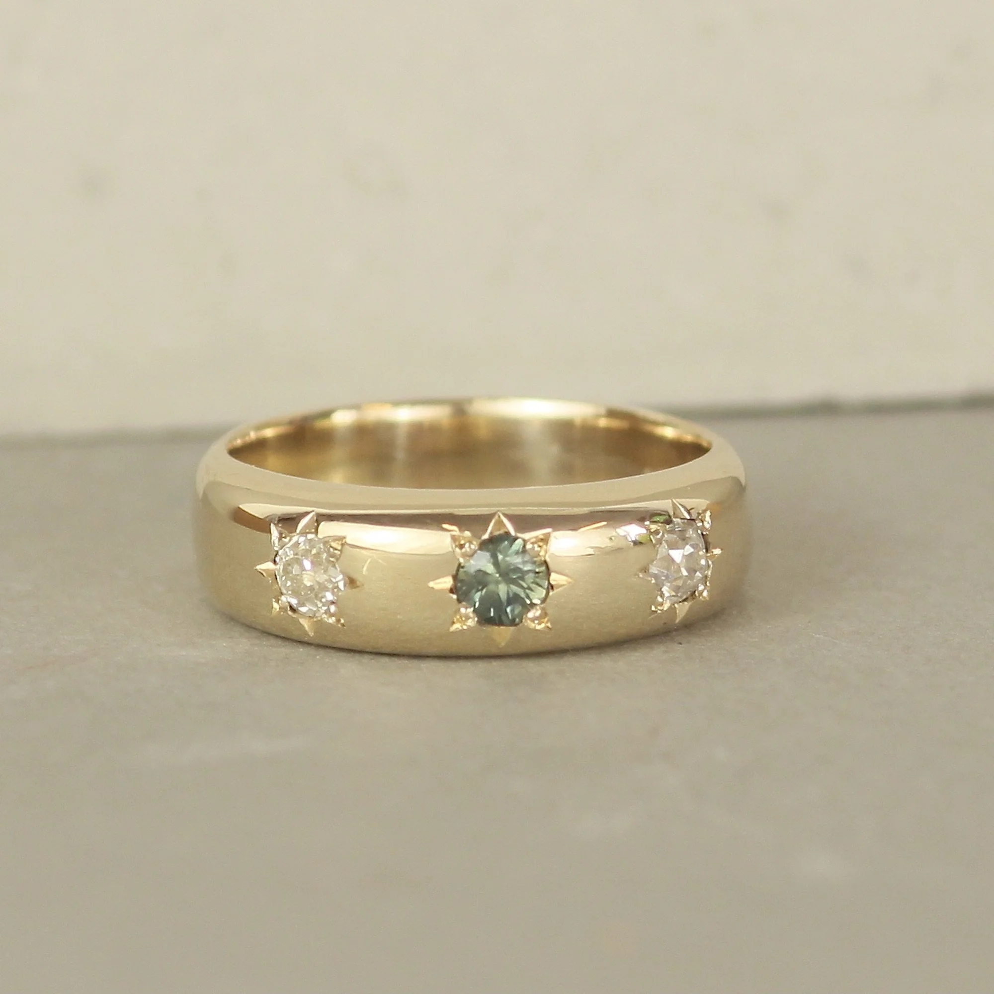 Bespoke chunky 9ct gold engagement ring with green sapphire and two inherited diamonds in star settings, handmade in East London