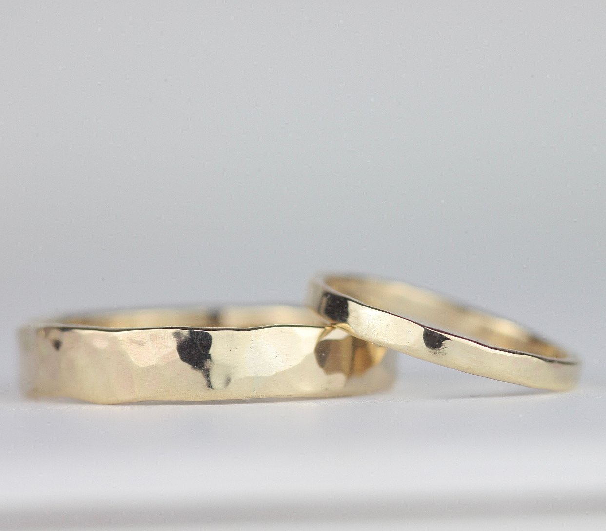wide hammered yellow gold wedding ring and slim hammered gold wedding ring