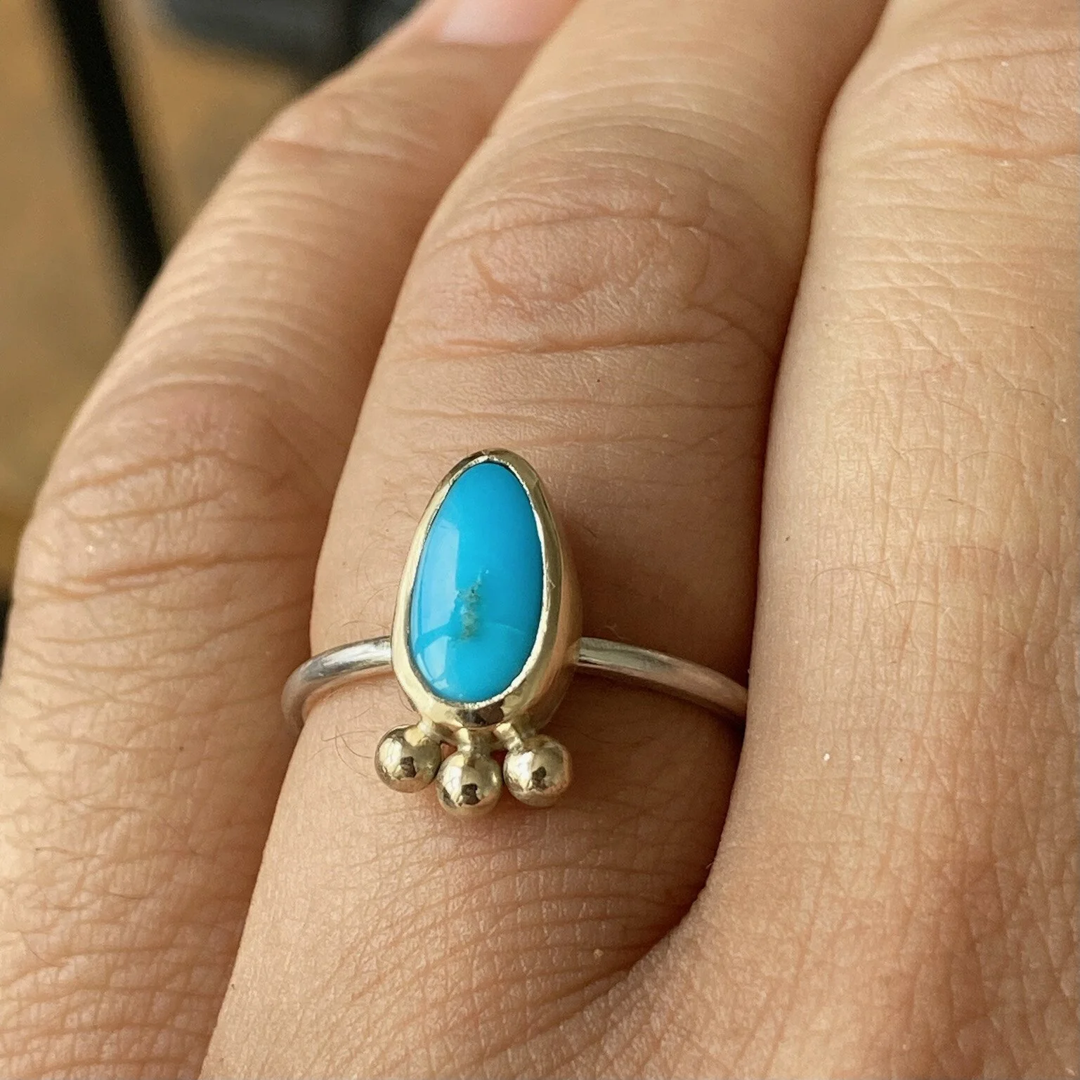 Small blue gemstone pear shaped ring in gold setting