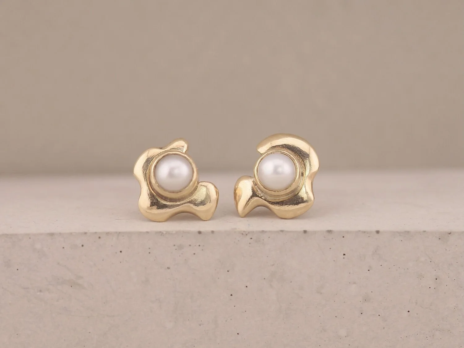 wavy gold abstract pair of earrings with pearls