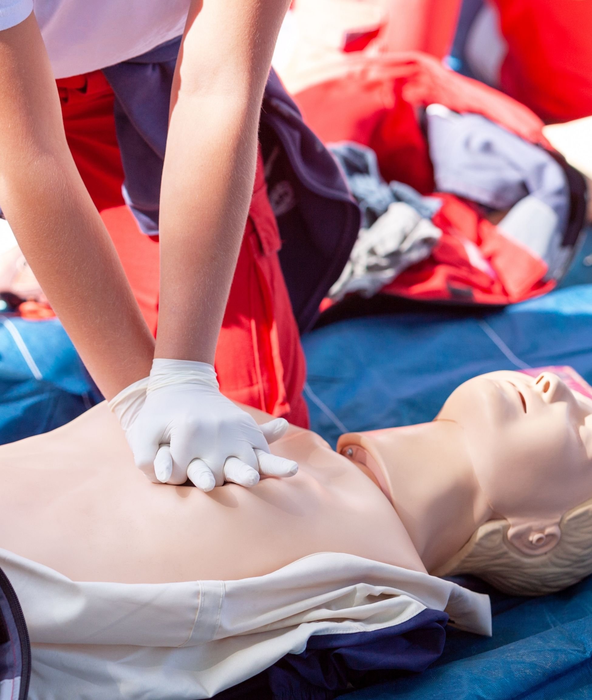A family of three watching a video call on a laptop, with an adult woman smiling on the screen, sitting on a couch.