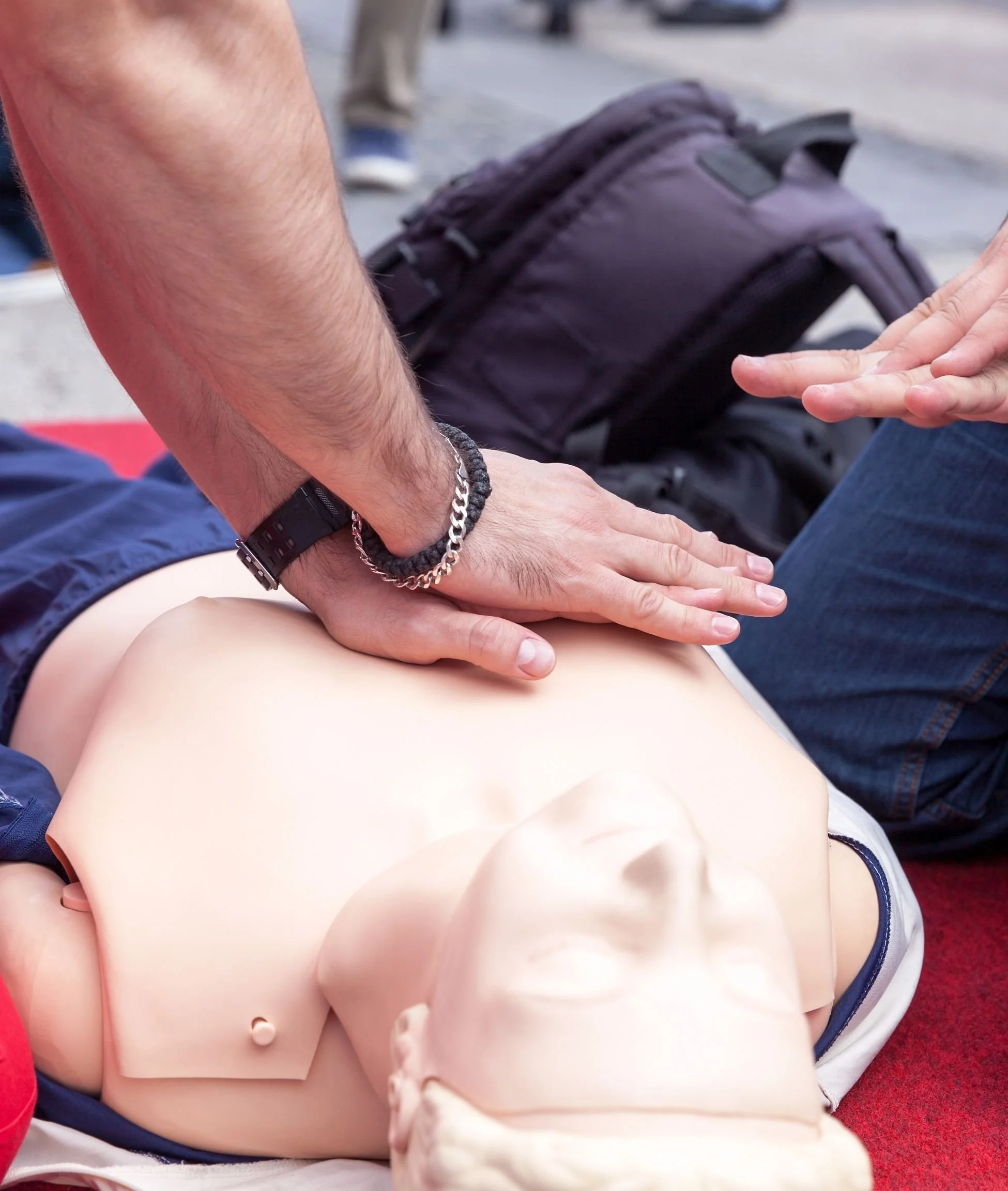 A digital device displaying a guide titled "Vysperkuj si lekárničku" with a pink background and illustrations of medical supplies including a red first aid kit, bandages, pills, and medicine bottles. Surrounding the device are four other pages with information and checklists related to first aid and medication, a small green plant at the bottom, and a blurred background.