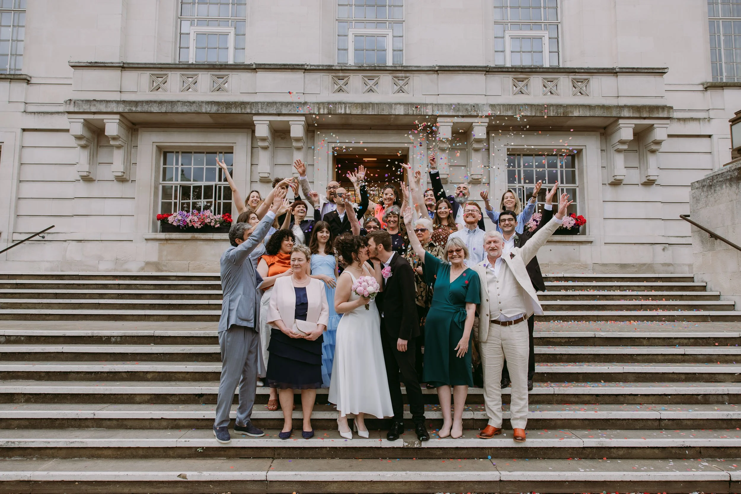 newly wed couple kissing + confetti outside hackney town hall in London