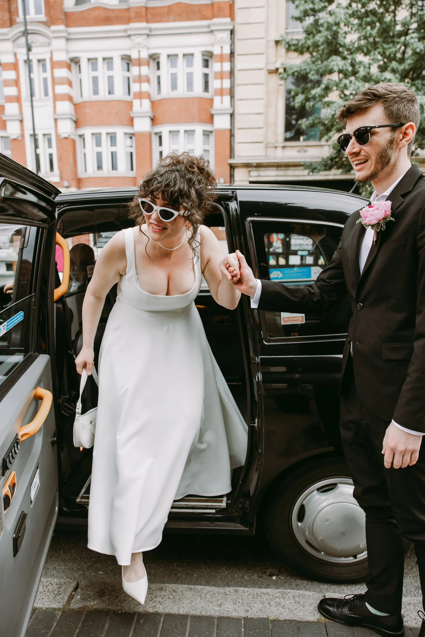 Bride and groom in taxi before Hackney Town Hall wedding in London