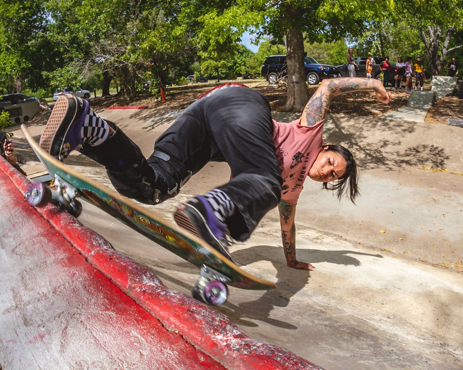 owner/women skater of color doing Bert grind on a concrete DIY obstacle