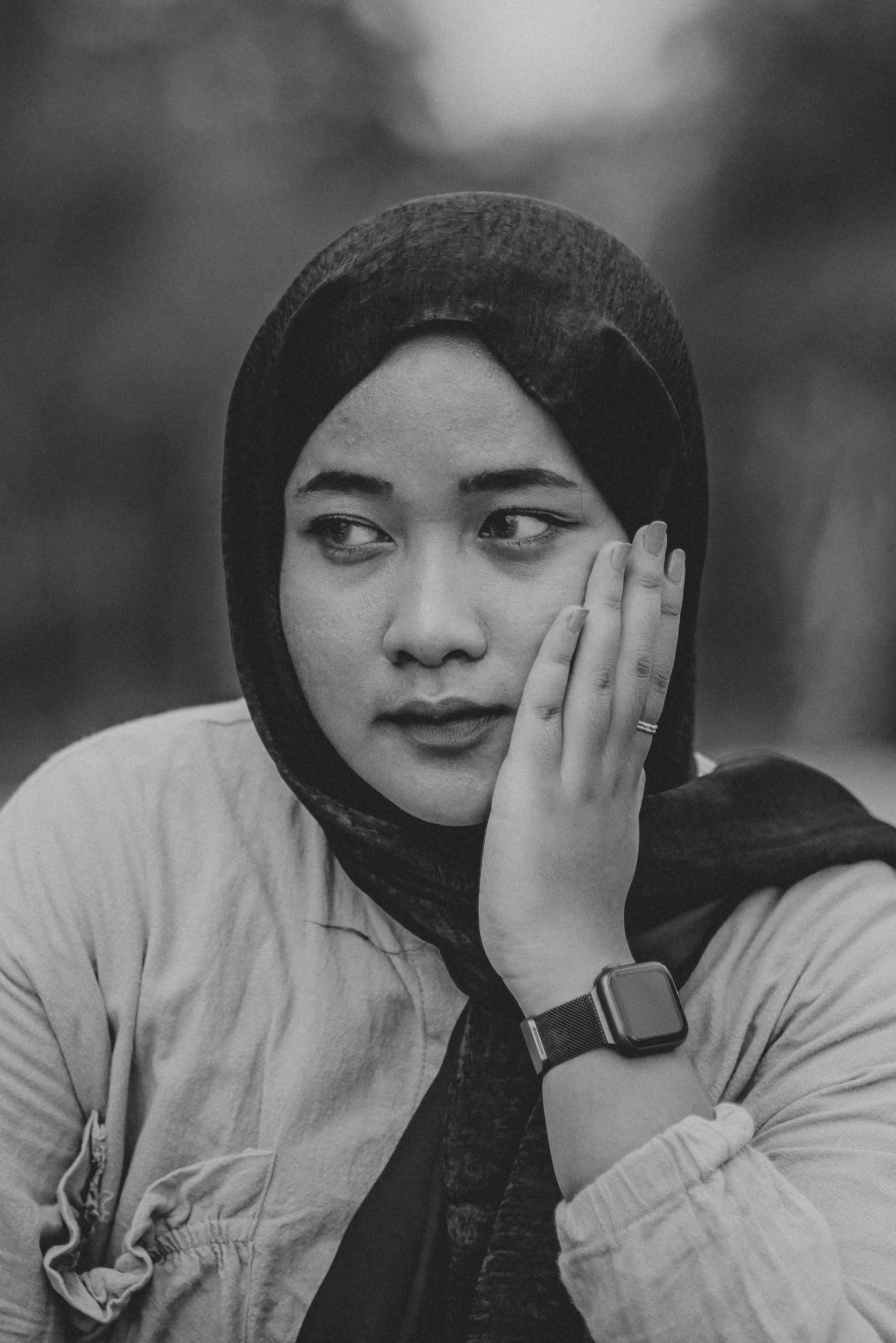 Hijabi Muslim woman looking off into the distance looking kind of sad.