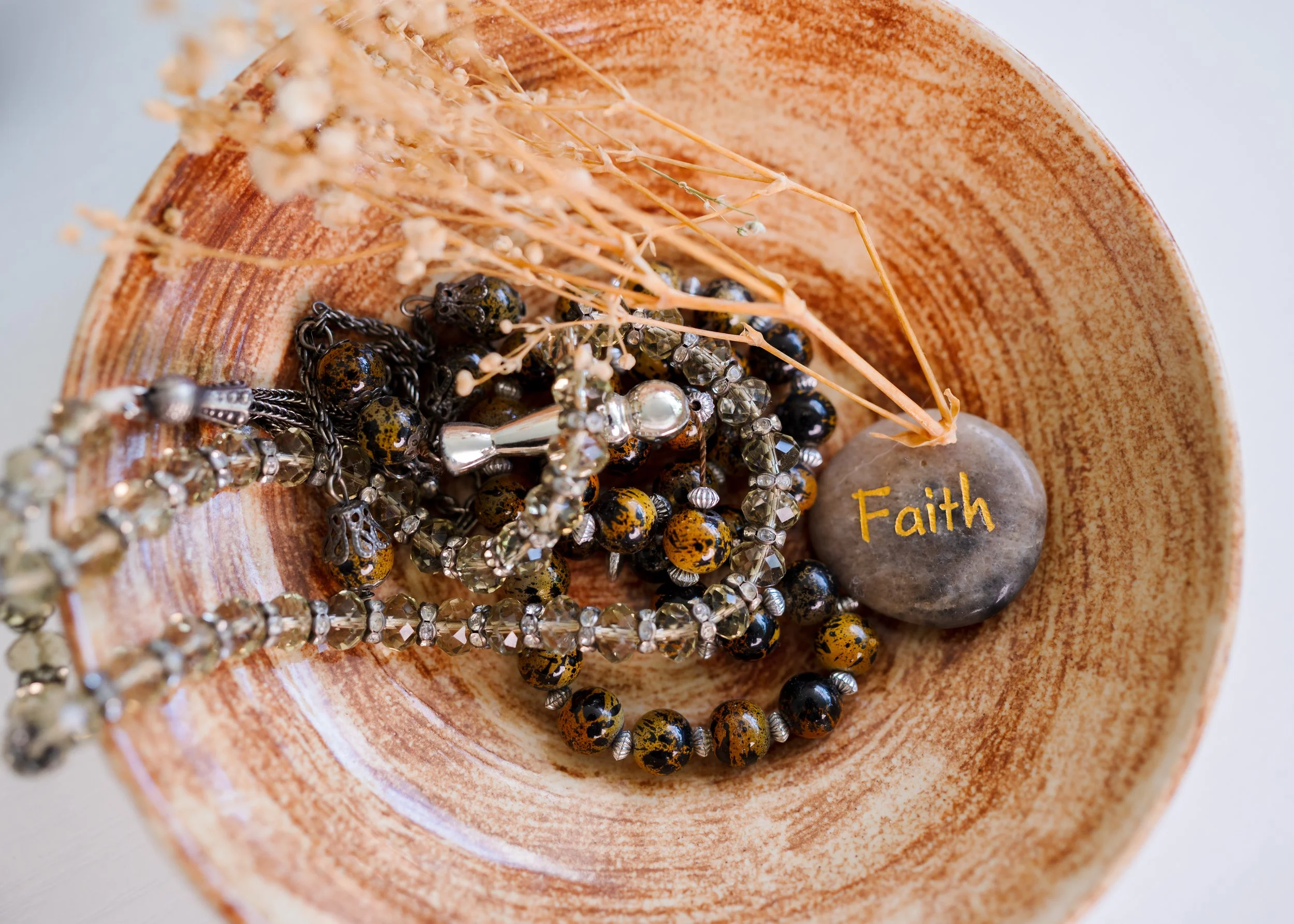 Tasbeeh beads and stone that has 'faith' carved into it