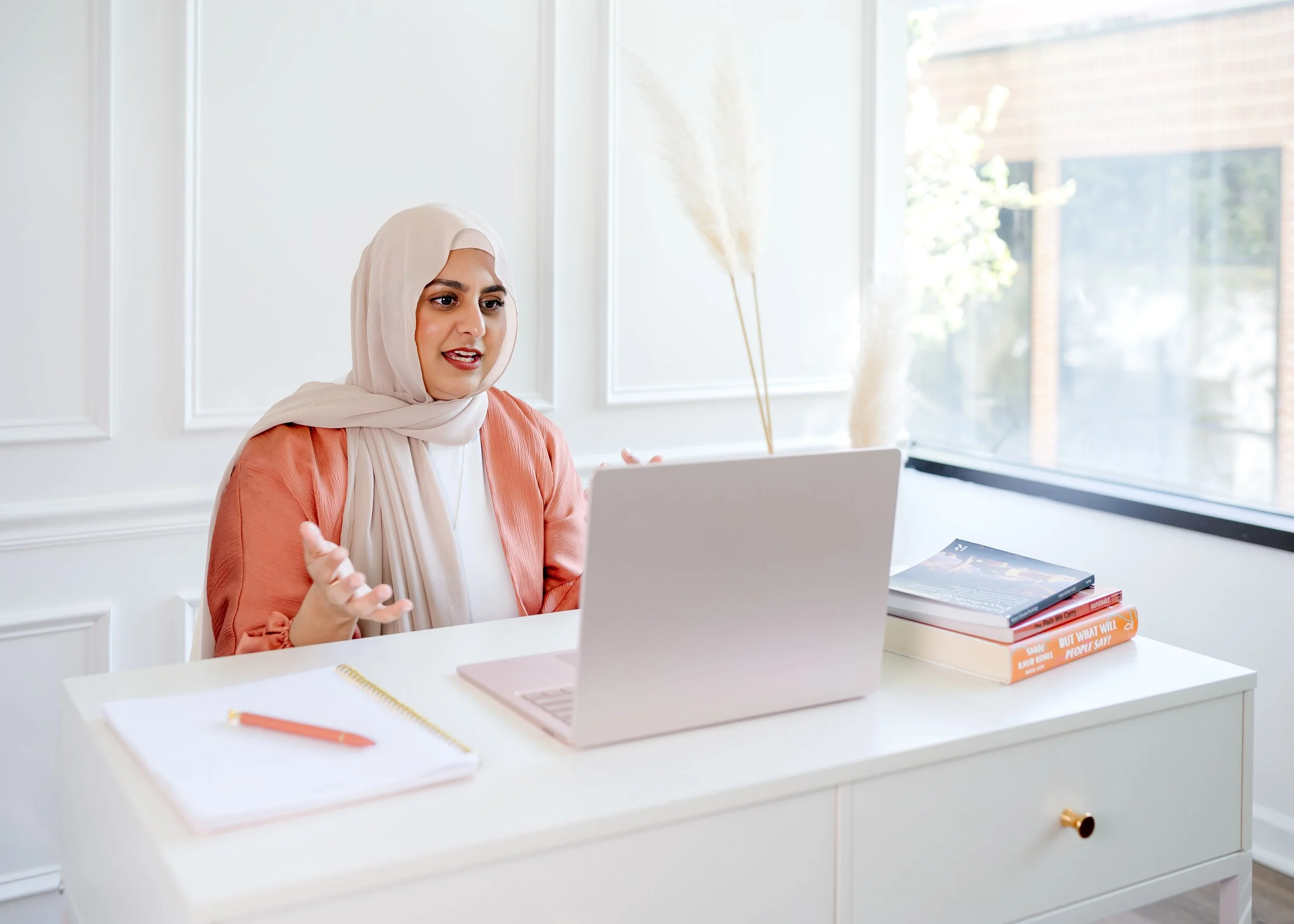 Therapist Natasha Deen talking with a client online in a telehealth appointment on her laptop