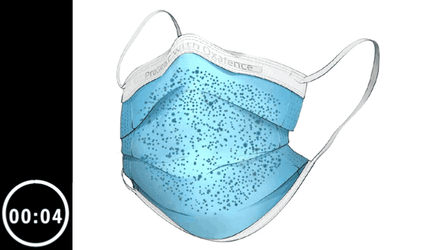 A blue disposable face mask with black and blue speckles, showing ear loops and a nose strip, designed for protection against airborne particles.