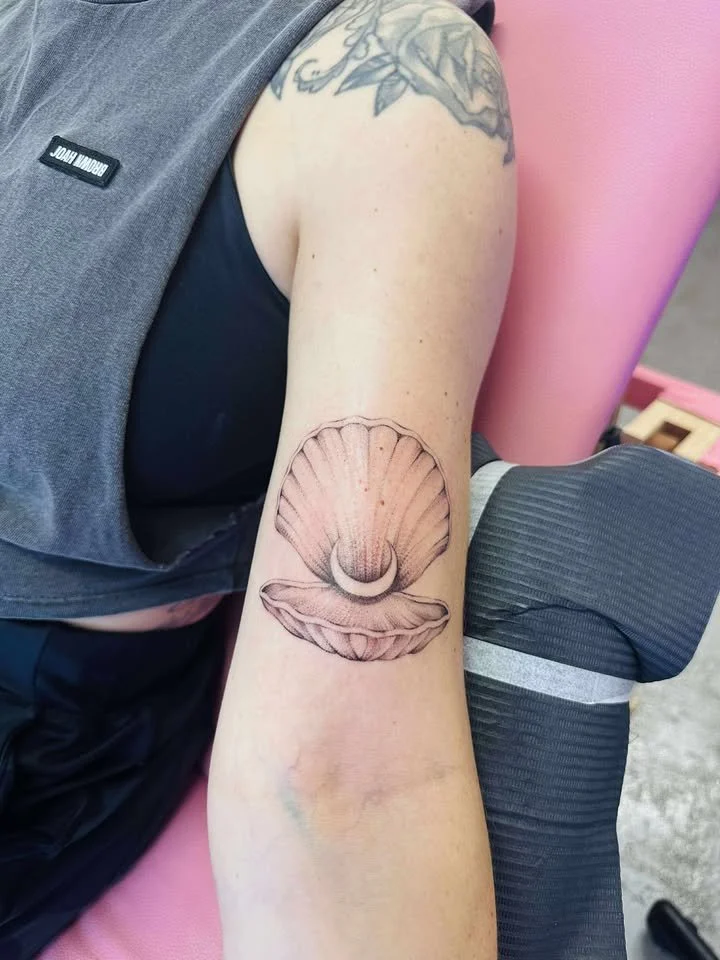 Tattoo of a surreal bee with multiple eyes on a person's upper back.