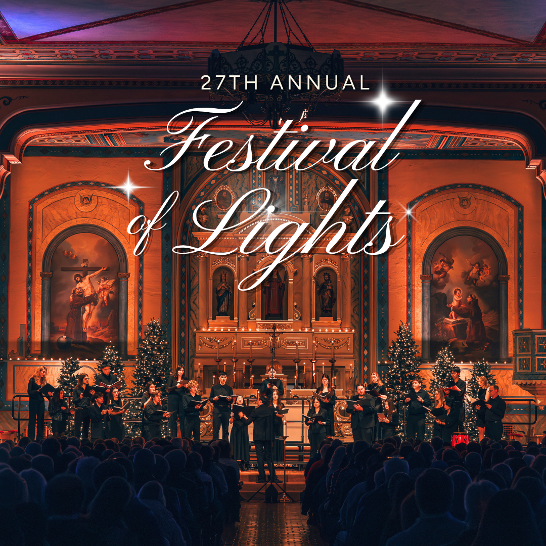 Santa Clara University choirs perform before a full audience inside the decorated Mission Santa Clara, surrounded by illuminated Christmas trees.