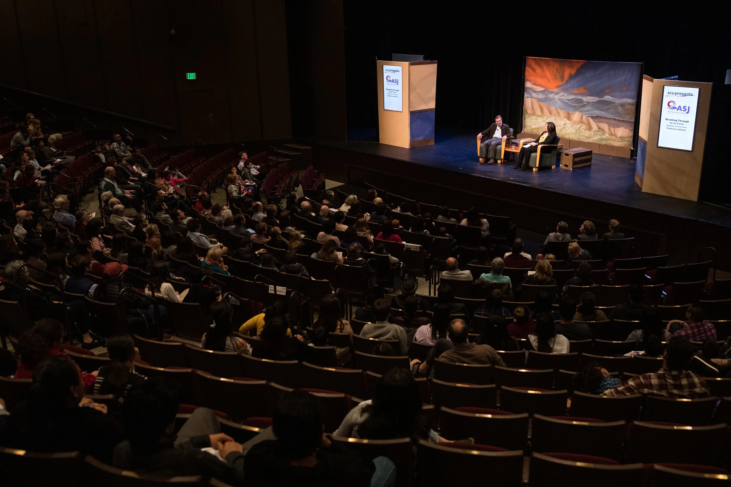 Audience listening to Francisco Jimenez speak on his experiences on stage in the Louis B. Mayer Theatre at Santa Clara University. 