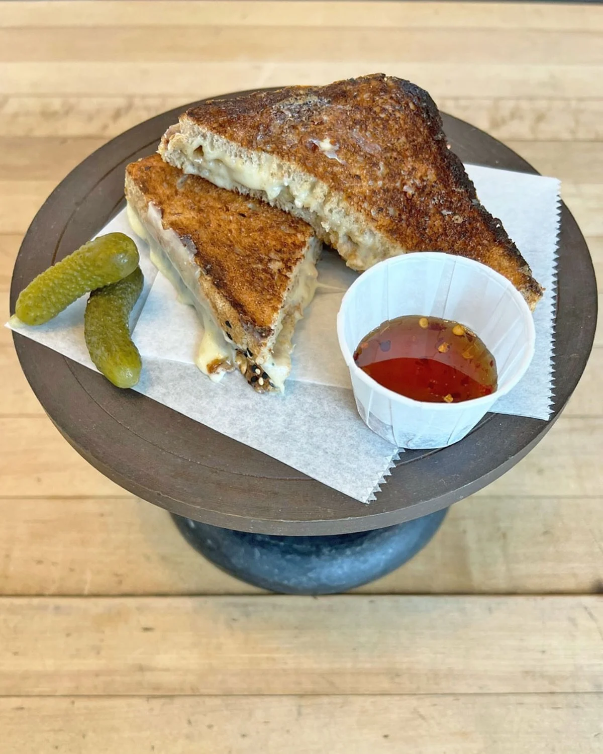 ☆ NEW MENU ITEM ☆
A grilled cheese sandwich with a blend of Gouda, Cheddar and Gruyere on Ancient Grain Pullman served with a side of Hot Honey &amp; Pickles!