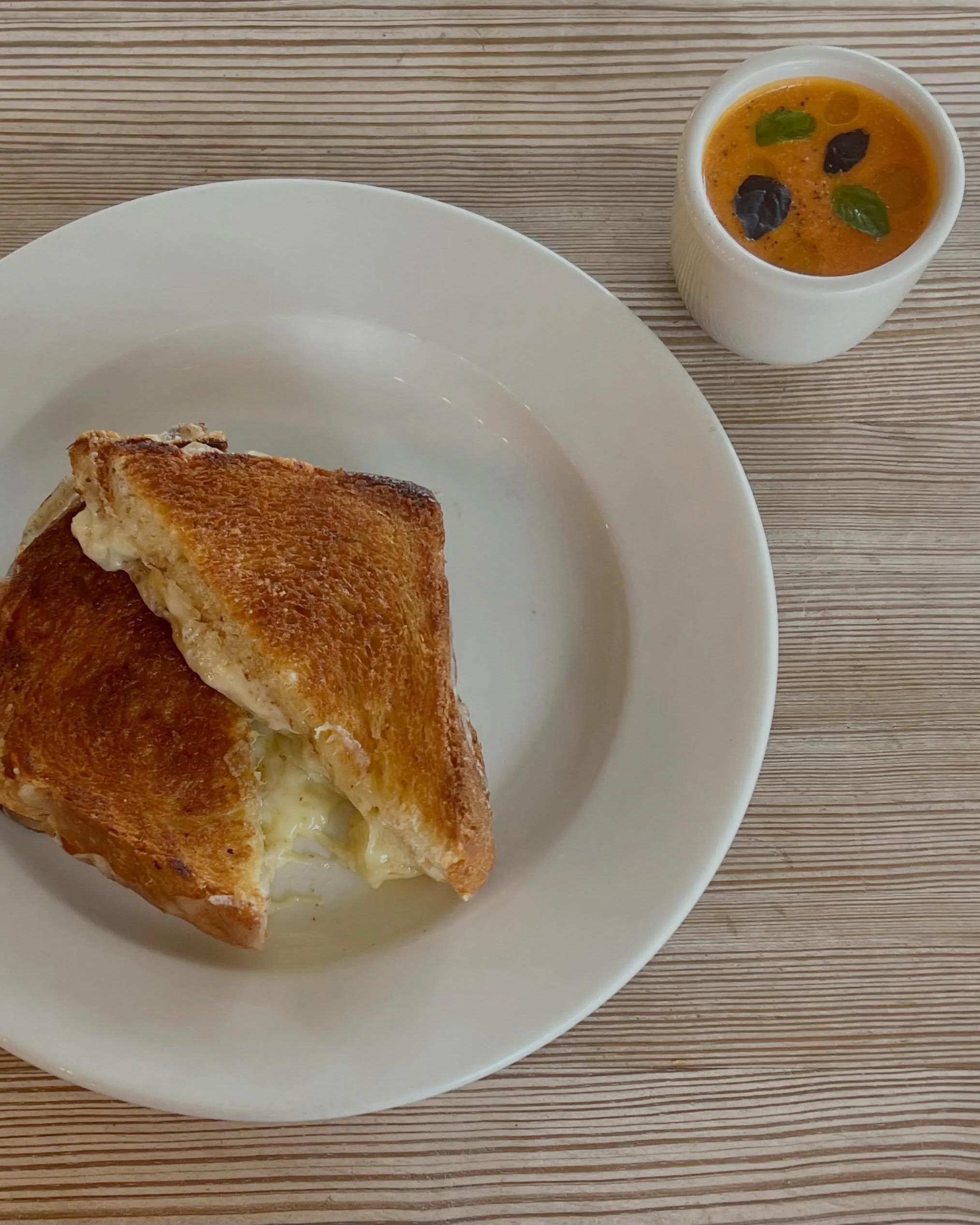 New to the lunch menu!  A classic grilled cheese, with gruyere, gouda, white cheddar, and mozzarella cheeses with a cup of tomato basil soup 😊