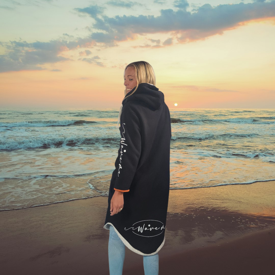 Woman in WaveMe StayDri Long Hoody in Black on beautiful beach shore