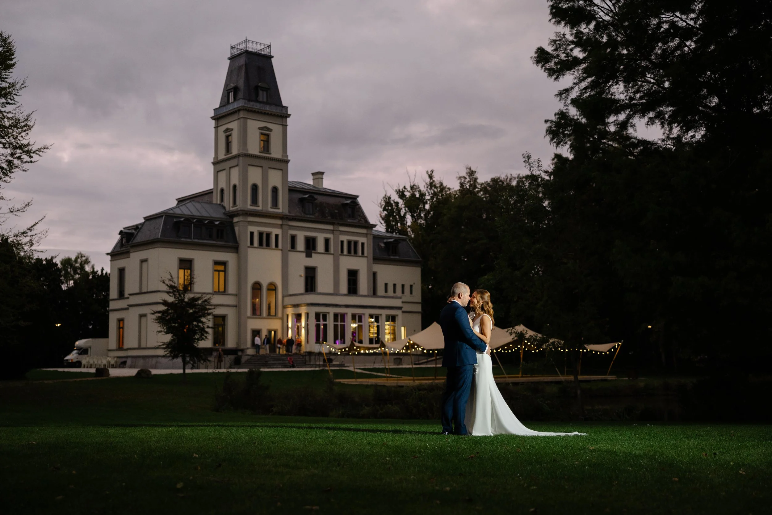 bruidspaar poseert tijdens een stijlvolle avondfotoshoot bij een kasteel, vastgelegd door trouwfotograaf uit Nijmegen
